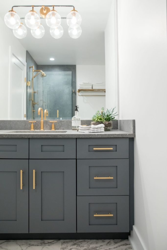 Grey bathroom vanity with gold hardware in luxury okanagan residential renovation.