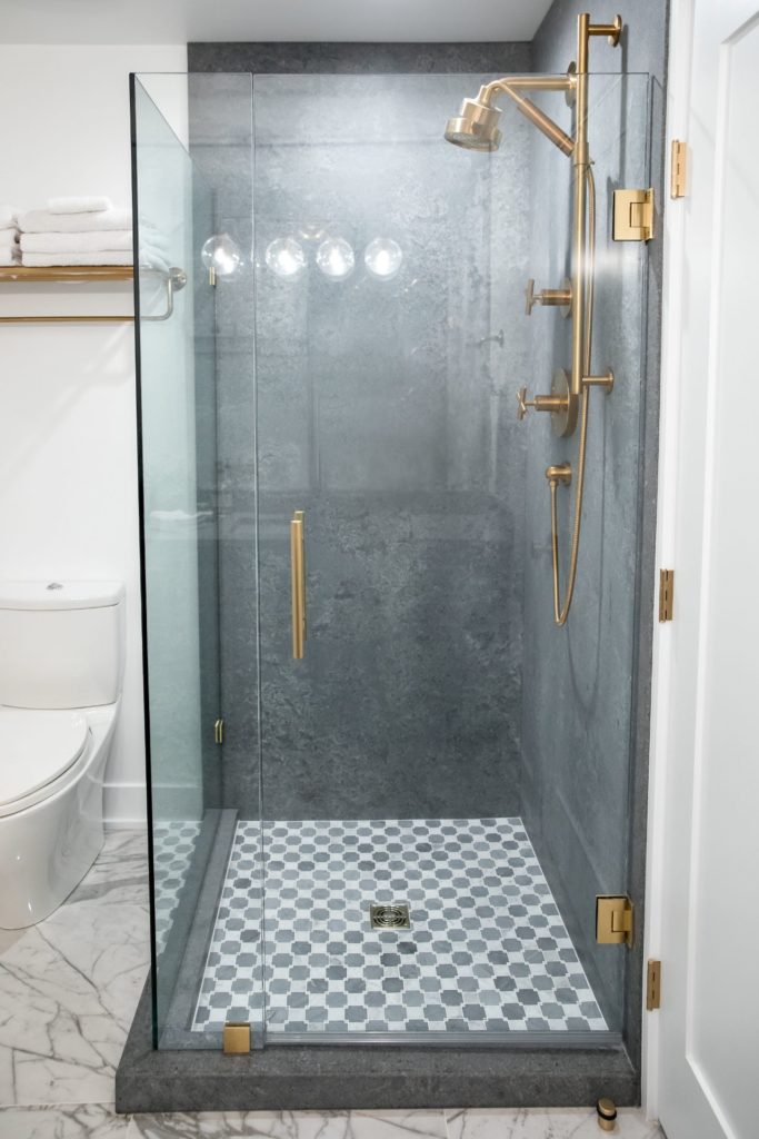 Grey shower vanity with gold fixtures in upscale Kelowna home.