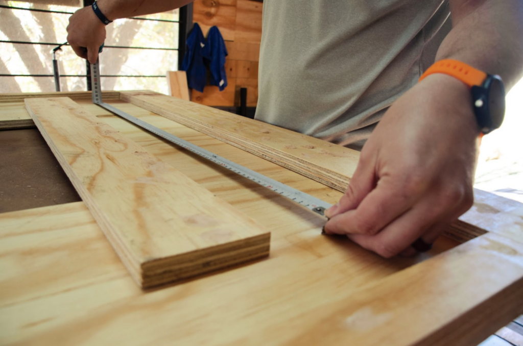 a man measuring custom millwork with a measuring tape